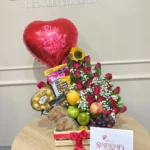Desayuno sorpresa con rosas, girasol, frutas y globo metalizado
