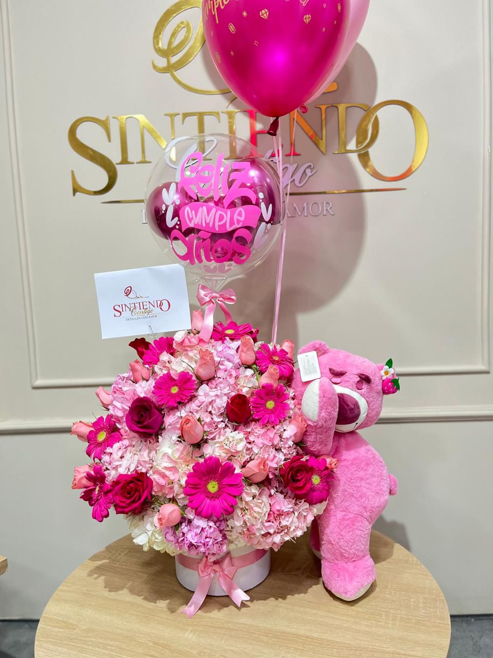 Cilindro en hortensias, gerveras, rosas, globos con helioy peluche