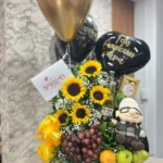 Arreglo floral con girasoles, frutas, cerveza, Ferrero Rocher, peluche y globos con helio